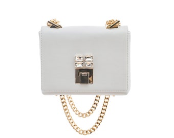 May include: A white leather crossbody bag with a gold chain strap and a crystal embellished clasp.