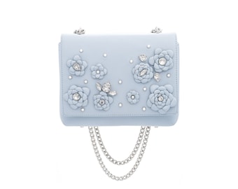 May include: A light blue shoulder bag with a chain strap and 3D floral embellishments with rhinestones.