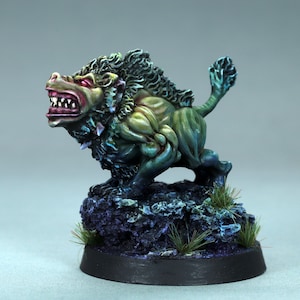 May include: A green and blue painted miniature of a snarling, wolf-like creature with a mane of green fur. The creature is standing on a rocky base with green grass.