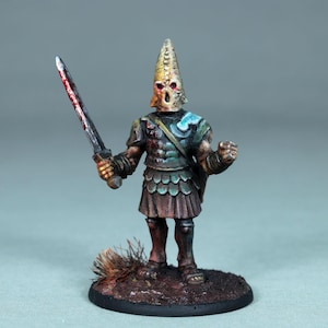 May include: A miniature figurine of a warrior in armor, holding a bloodied sword. The figure has a conical helmet with skull-like features and a green and brown color scheme. The base is dark brown, and the overall aesthetic suggests a fantasy theme.