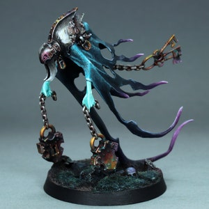 May include: A ghostly figure with a teal and purple cloak, holding two rusty chains with padlocks. The figure is painted in a detailed and realistic style.