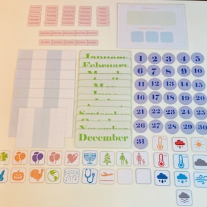 Puede incluir: Un conjunto de tarjetas laminadas de colores para enseñar a los niños los días de la semana, los meses del año y los números. Las tarjetas presentan una variedad de imágenes, incluyendo un trébol, una calabaza, un pavo, un globo terráqueo, fuegos artificiales, un estetoscopio, un avión, una menorá, un árbol de Navidad, una familia, un termómetro, una nube, un copo de nieve y un sol.