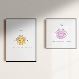 May include: Two framed prints with illustrations of chakras. The left print features a yellow chakra with the Sanskrit symbol and the word "Manipura" in black script. The right print features a pink chakra with the Sanskrit symbol and the word "Sahasrara" in black script.