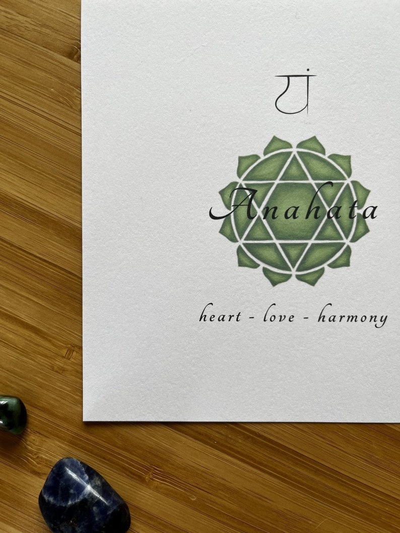 May include: A green and white illustration of the Anahata chakra, the heart chakra, with the Sanskrit symbol "ya" above it. The text "heart - love - harmony" is below the illustration.