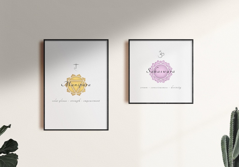 May include: Two framed prints with illustrations of chakras. The left print features a yellow chakra with the Sanskrit symbol and the word "Manipura" in black script. The right print features a pink chakra with the Sanskrit symbol and the word "Sahasrara" in black script.