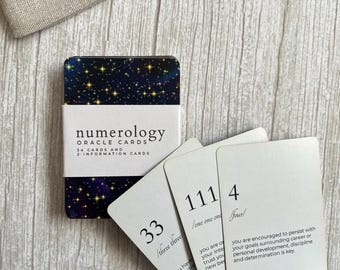 Könnte beinhalten: Ein Numerologie-Orakelkarten-Set mit einer Box im dunkelblauen Sternenhimmel-Design, begleitet von drei weißen Karten mit den Zahlen 33, 111 und 4 sowie beschreibendem Text, neben einem beigen Leinenbeutel mit der Aufschrift ankaur.