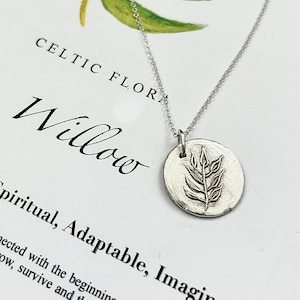 May include: A silver necklace with a round pendant featuring a detailed willow branch design. The pendant is engraved with the word "Willow" and the text "Spiritual, Adaptable, Imaginative".