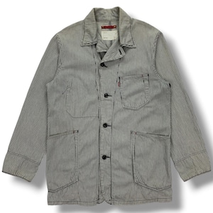 May include: A long-sleeve jacket featuring a white and navy blue pinstripe pattern. The jacket includes a pointed collar, a button-front closure with four dark buttons, two large lower patch pockets, and a single chest pocket with a small red tab.