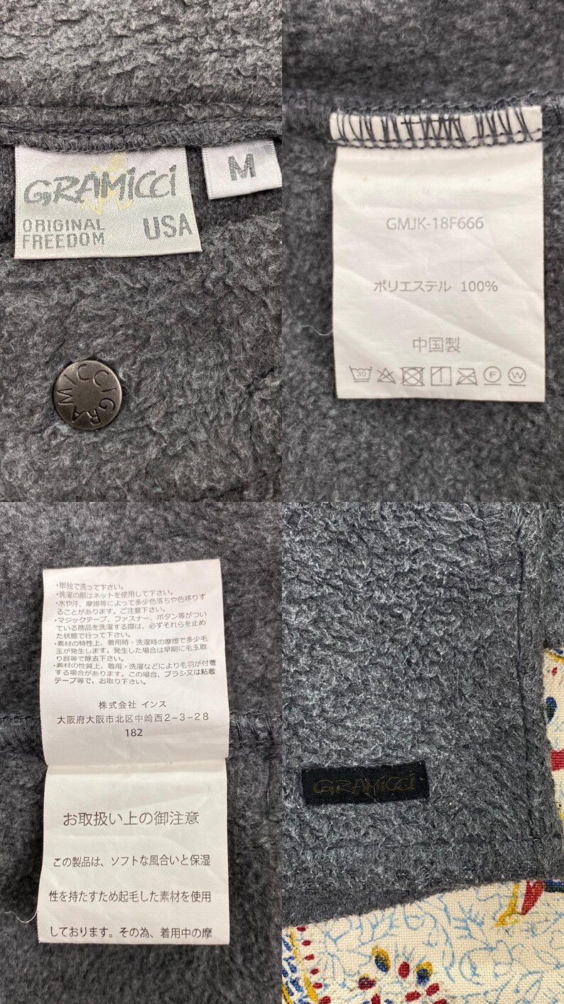 May include: Close-up of a gray Gramicci jacket with multiple tags. The tags include the brand name, size "M", and care instructions. The jacket is made of a soft, textured material.
