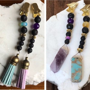 May include: Two pairs of beaded hair clips with tassels. One pair has purple and blue beads with a purple crystal and a light blue tassel. The other pair has yellow and purple beads with a blue and brown crystal and a pink tassel.