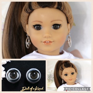 May include: A collage of images featuring a doll with brown hair, brown eyes, and silver hoop earrings. The doll is wearing a white shirt. The collage also includes a close-up of the doll's eyes, which are brown with black eyelashes. The text "Doll of a Kind" is visible in the collage.