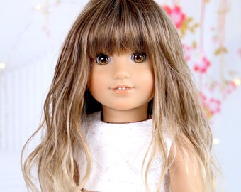May include: A doll with long, wavy, light brown hair with blonde highlights. She is wearing a white crop top and striped shorts.