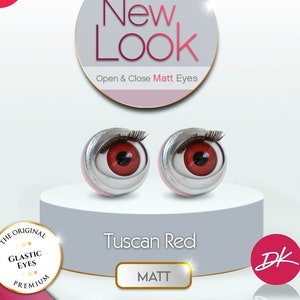 May include: A pair of red glass eyes with silver eyelids for doll making. The eyes are labeled "Tuscan Red" and "Matt". The eyes are part of the "New Look" brand and are described as "Open & Close Matt Eyes".