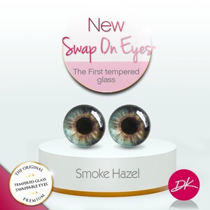 以下が含まれることがあります： 煙色のヘーゼルカラーのリアルなガラス製の目玉が2つ。目玉には「Smoke Hazel」と表示されており、「Swap On Eyes」ブランドの製品です。「The First tempered glass」というテキストも表示されています。