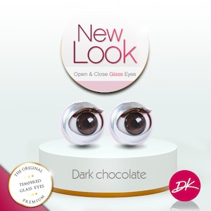May include: Two dark chocolate-colored glass eyes with eyelashes are displayed on a white pedestal. The text "New Look" and "Open & Close Glass Eyes" are above the eyes. The text "Dark chocolate" is below the eyes.