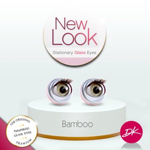 May include: Two stationary glass eyes with a light brown iris and a dark brown pupil. The eyes are set on a white platform with the words "New Look" and "Stationary Glass Eyes" above them. The words "Bamboo" and "DK" are below the eyes.