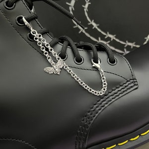 May include: Black leather boot with a silver chain and butterfly charm attached to the laces.