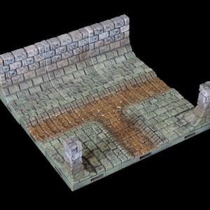 May include: A set of modular dungeon tiles featuring a stone wall and a cobblestone path with a muddy section. The tiles are designed for tabletop gaming and role-playing.