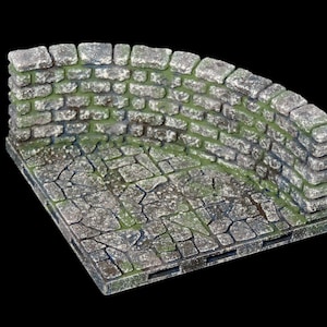 Pode incluir: Um canto de parede de pedra com um piso de paralelepípedos musgoso. A parede é feita de pedras ásperas cinzas com musgo verde crescendo nas fendas. O piso é feito de pedras cinzas irregulares com uma leve camada de musgo.