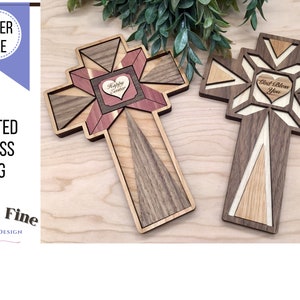 Puede incluir: Dos diseños de cruces acolchadas de madera con un corazón en el centro. La cruz de la izquierda tiene el texto "Feliz Pascua" en el corazón. La cruz de la derecha tiene el texto "Que Dios te bendiga" en el corazón.