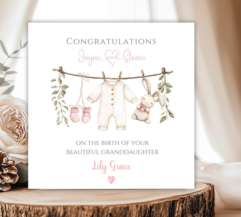 May include: A baby announcement card with the words "Congratulations" and "On the birth of your beautiful granddaughter". The card features a watercolour illustration of baby clothes, a bunny, and greenery hanging on a washing line. The baby's name is "Lily Grace".