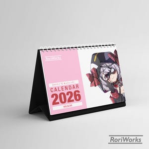 May include: A desk calendar for the year 2026 with a pink cover and a black stand. The calendar features a cartoon illustration of a character with a black and red outfit. The word "CALENDAR" and the year "2026" are prominently displayed.