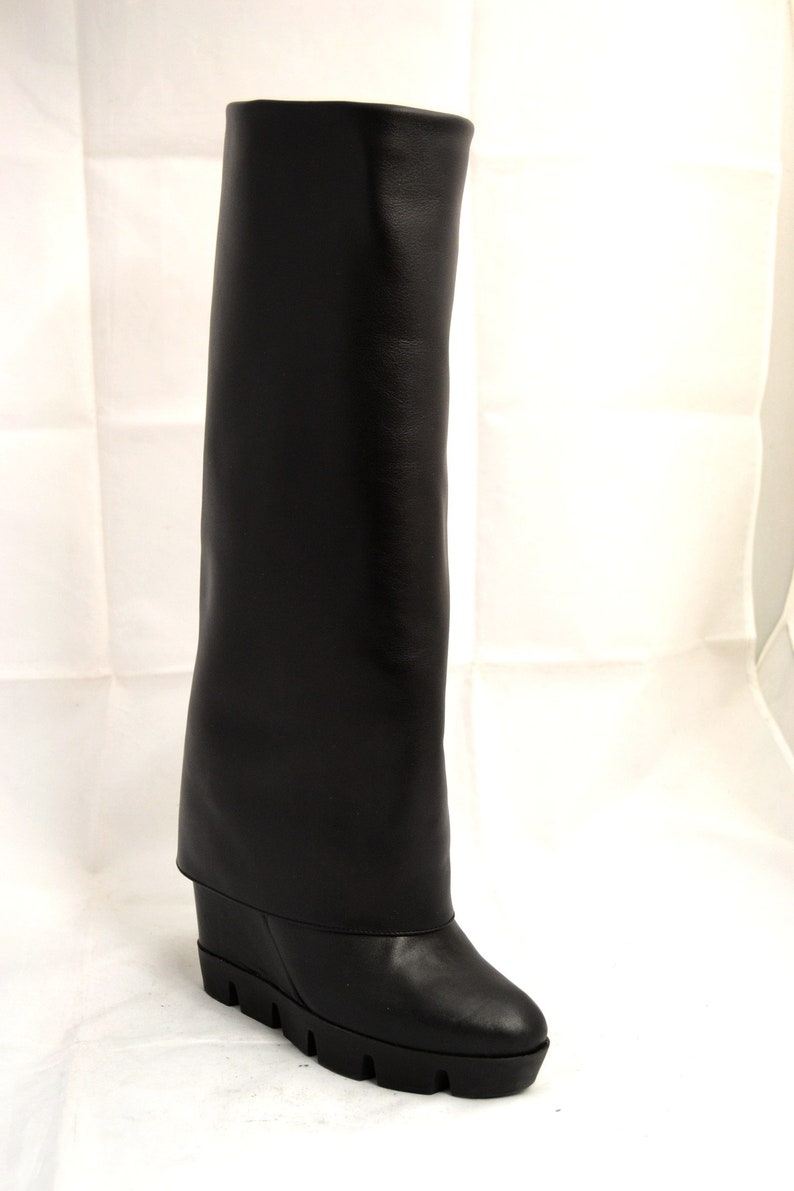 Peut inclure: Bottines noires en cuir montant au genou avec un talon compens&eacute; et une semelle plateforme &eacute;paisse.