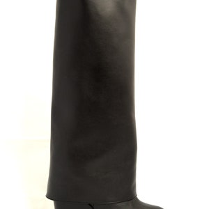Peut inclure: Bottines noires en cuir &agrave; plateforme compens&eacute;e avec un revers.