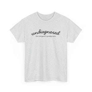 May include: A gray t-shirt with the text "undisagnosed but everyone's pretty sure" printed in black.