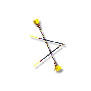 May include: Two juggling batons crossed in an X shape. Each baton features a black handle, a central section wrapped in diagonal stripes of yellow, pink, and black, and a bright yellow fringed end piece with banded accents.