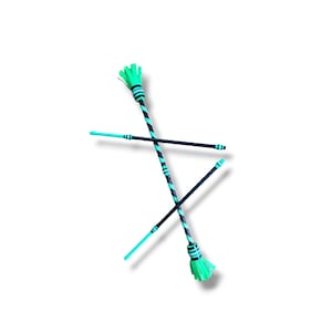 May include: Two juggling batons featuring a black and neon green spiral pattern along the shafts. Each baton has a neon green fringed end and a black handle section. The batons are positioned in a crossed formation against a white background.