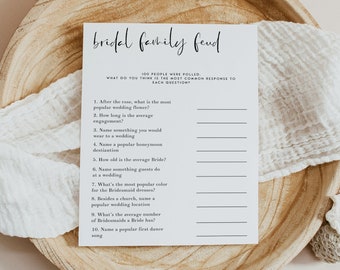 May include: A white card with the text "bridal family feud" in black script. The card has a list of 10 questions about wedding traditions, with lines for writing in answers.
