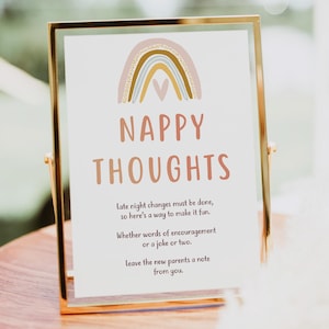 Op de afbeelding: Een gouden lijst met een regenboog en een hartontwerp. Het bord heeft de tekst "Nappy Thoughts" en bevat de tekst "Late night changes must be done, so here's a way to make it fun. Whether words of encouragement or a joke or two. Leave the new parents a note from you."