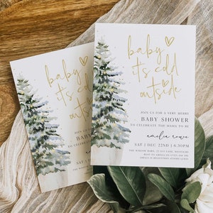 May include: A baby shower invitation with a watercolor illustration of two pine trees with lights. The text reads "baby it's cold outside" with a heart symbol. The invitation is for Amelia Cove and includes the date, time, and location of the shower.