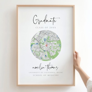 May include: A framed print with a map design, featuring the text "Graduate" and "Class of 20XX". The map is centered with a red marker, and the name "amelia thomas" is written below. The print is from the University of California, Irvine School of Medicine.