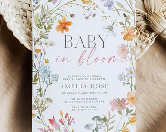 Op de afbeelding: Een rechthoekige witte uitnodigingskaart voor een babyshower met een kleurrijke aquarel bloemenrand. De tekst luidt: BABY in bloom, PLEASE JOIN US FOR A BABY SHOWER TO CELEBRATE AMELIA ROSE, SATURDAY AUGUST 12TH AT 4PM, THE WILLOW BARN, 22 HIGH STREET, WESTACRE, RSVP TO LAUREN ON 07123 456 456.