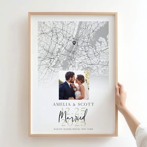 Può includere: Stampa di matrimonio incorniciata con una mappa della città e una foto di una coppia. La stampa include i nomi "Amelia & Scott", la data "12.25.2025" e la parola "Married" in corsivo, e la località "Martin Manor House, New York."