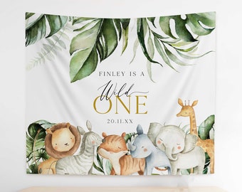 May include: White fabric backdrop with a jungle theme, featuring watercolor illustrations of a lion, zebra, tiger, rhino, elephant, and giraffe. The text "FINLEY IS A Wild ONE" is displayed in gold and black.