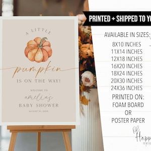 May include: A baby shower sign with a watercolor pumpkin illustration. The sign reads "A Little Pumpkin is on the Way!" and welcomes guests to Amelia's baby shower. Available in various sizes, printed on foam board or poster paper.