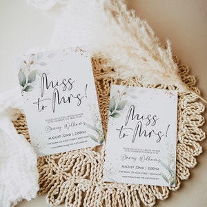 May include: Two white cards with green and gold floral designs and the text "Miss to Mrs!"  The cards are on a woven straw mat. The text on the cards reads: "Please join us for a bridal shower as we celebrate the bride to be Darey Williams August 22nd | 2:00pm The Barn, 22 High Street, Westacre"