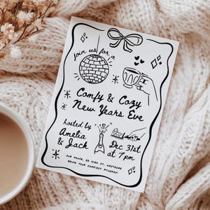 May include: A monochrome New Year's Eve invitation featuring a disco ball, teacup, and champagne bottle. The text says "Comfy & Cozy New Years Eve", hosted by Amelia & Jack, with the date and time details.