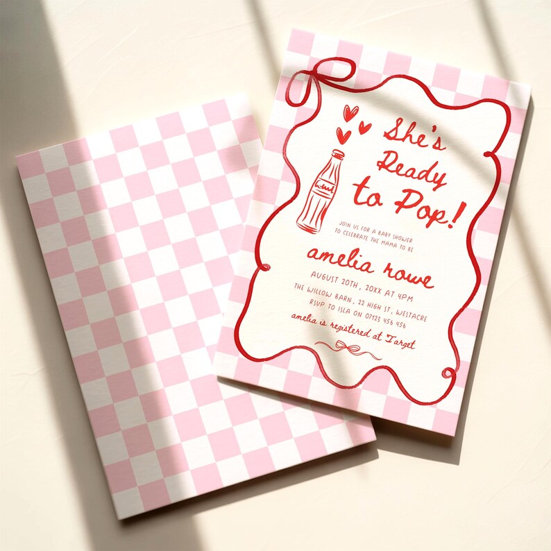 May include: Pink and white checkered baby shower invitation with the text "She's Ready to Pop!" in red script. The invitation features a red border and a drawing of a soda bottle. The back of the invitation has a pink and white checkered pattern.