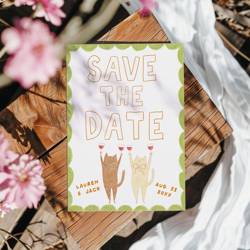 May include: A white "Save the Date" card with a green scalloped border. The card features the text "SAVE THE DATE" in gold lettering, along with two cartoon cats raising wine glasses. The names "Lauren & Jack" and the date "Aug 11 20XX" are also included.