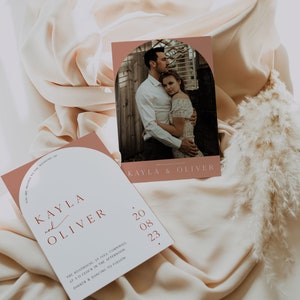 Puede incluir: Una invitaci&oacute;n de boda con un fondo melocot&oacute;n y una foto de una pareja en un jard&iacute;n. La invitaci&oacute;n dice "Est&aacute;s invitado a la boda de Kayla y Oliver" e incluye la fecha "20 08 23".