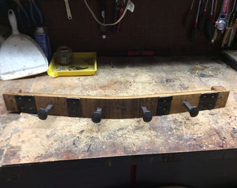 May include: A wooden coat rack with four metal hooks. The rack is made from reclaimed wood and has a rustic look.