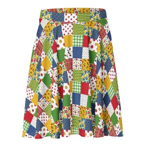 May include: A colorful, patchwork-style skirt featuring a variety of patterns and colors. The skirt's design includes squares of red, yellow, green, and blue with floral, plaid, and polka dot patterns. The skirt has a flared silhouette.