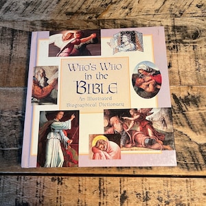 May include: A hardcover book titled "Who's Who in the Bible" with an illustrated biographical dictionary. The cover features various religious illustrations in a collage format, with a light purple border and a wooden background.