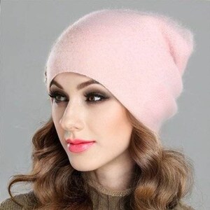 Op de afbeelding: Een zachte, roze beanie muts van cashmere. De muts is slouchy en heeft een simpel ontwerp.