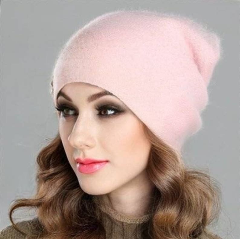 Op de afbeelding: Een zachte, roze beanie muts van cashmere. De muts is slouchy en heeft een simpel ontwerp.