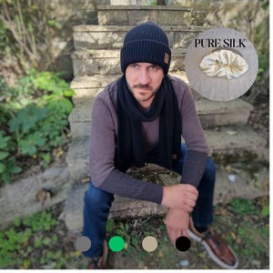 May include: A black ribbed knit beanie with a small tan tag and a matching black scarf. An inset circle shows a cream-colored silk scrunchie with the text PURE SILK. Four small colored circles in gray, green, beige, and black appear at the bottom.